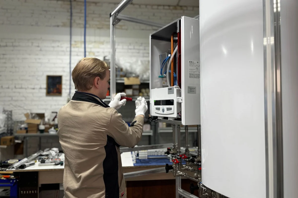 Techniker prüft eine wandhängende Heizungsanlage