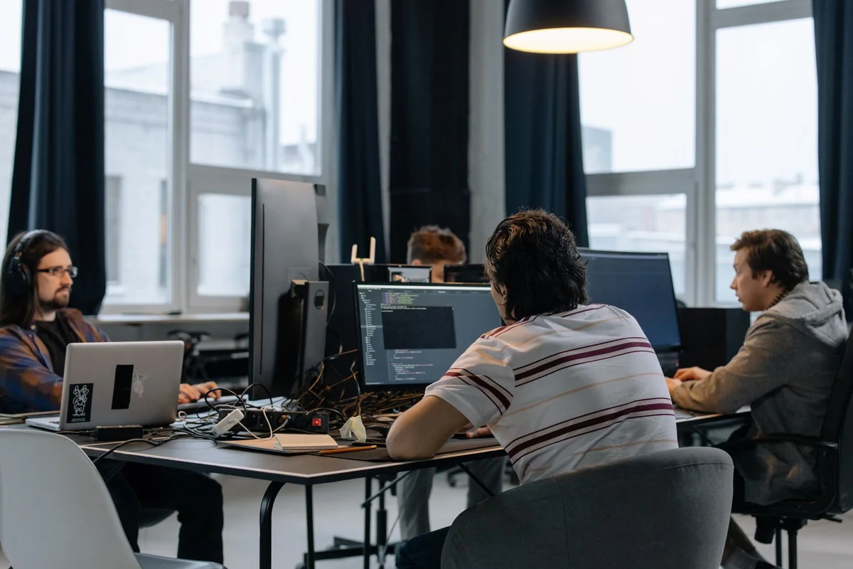 Entwicklerteam bespricht eine Softwarelösung am Bildschirm