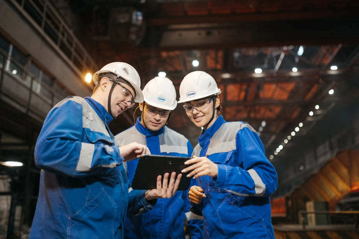 Techniker sehen sich gemeinsam ein Tablet in einer Industriehalle an